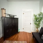 An armoire sits in a room with East Asian-style furniture.