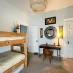 A desk sits in a room decorated in African and South Asian styles.